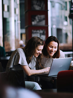 Zwei Frauen schauen auf den Bildschirm eines Laptops